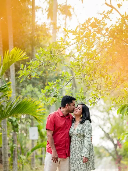 A tender kiss on the cheek during a pre-wedding shoot. The golden light of the late afternoon adds a warm, romantic glow to the scene.