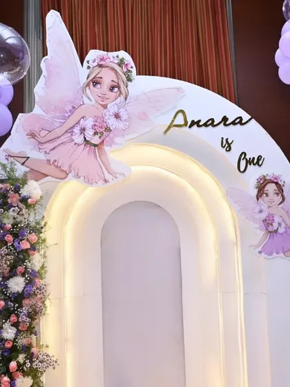 A close-up of the cake area from 'Anara's Onderland' party. The lighted arches and fairy cutouts create a beautiful focal point.