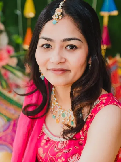 A beautiful close-up portrait of the bride during her Haldi, showcasing her delicate jewelry and happy expression.