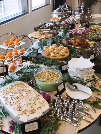 Hot dishes, salads and little desserts fill our end-of-summer office party spread, arranged among greenery and tiered serving stands.