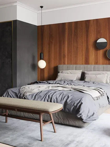 A modern bedroom featuring a grey upholstered bed and a wooden bench. The mix of textures and tones creates a sophisticated and calming atmosphere, perfect for rest and relaxation.