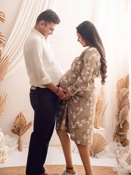A tender moment between expecting parents, framed by a soft, boho-inspired backdrop. I love capturing the anticipation and shared smiles in these couple pregnancy photos.