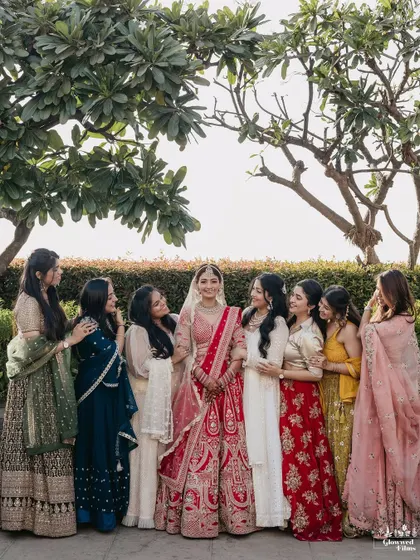 A beautiful outdoor group portrait of the bride and her bridesmaids, all dressed in a stunning array of colors.