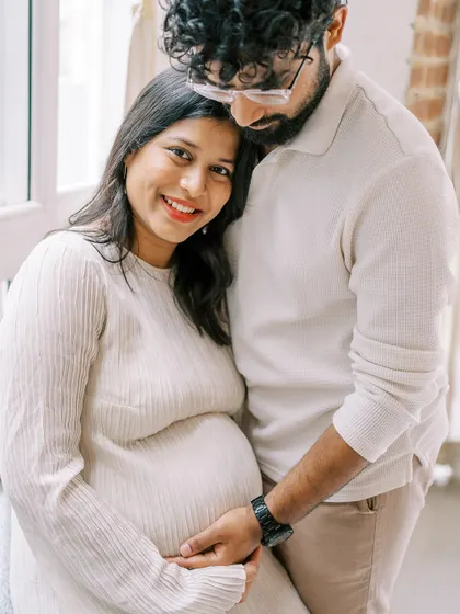 A warm and happy portrait of an expecting couple. Her leaning on his shoulder shows their support for one another during this journey. The genuine smiles are what make the photo special.