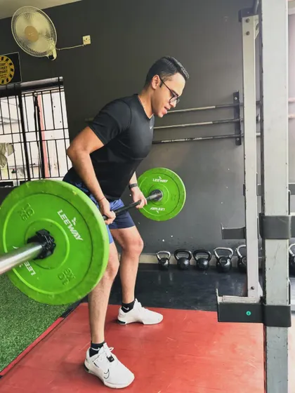 A client performs a bent-over row with a barbell, a foundational movement for back strength.