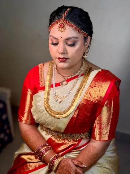 A close-up of the bride's muhurtham makeup. The focus is on creating a smooth, radiant complexion with beautifully defined eyes and lips, ensuring she looks flawless for her main ceremony.