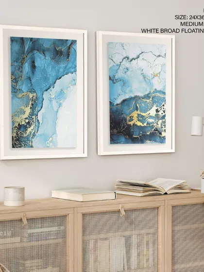 Our set of two indigo and gold abstract prints, elegantly presented in white broad floating frames. This combination is perfect for a refined space, adding a touch of modern luxury above a credenza.