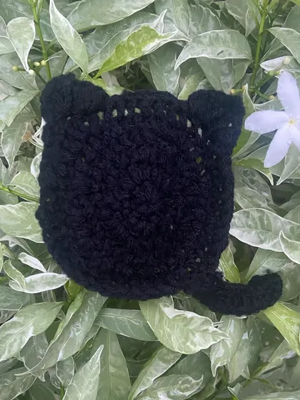 A close-up of my black cat coaster, perfect for your desk. It has little ears and a tail, and it's one of my favorite things to make.