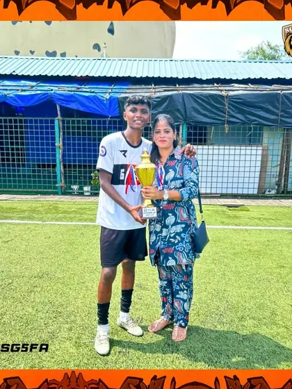 A player and his mother holding the runner-up trophy. We are proud to have such a strong support system from our parents.