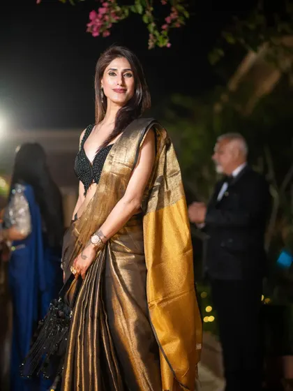 There is a quiet power in a well-draped saree. Here, I’m styled in a timeless black and gold silk saree for an evening event. This look embodies the grace and confidence I instill in my clients, showing how traditional wear can be both modern and incredibly elegant.