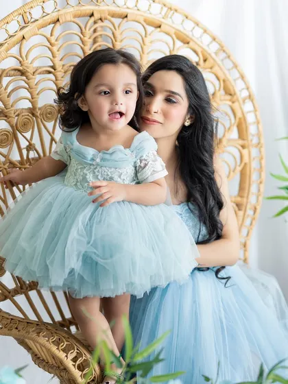 A sweet moment between a mother and her little girl. The matching light blue dresses and floral decor create a dreamy and serene atmosphere.