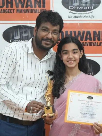 A teacher proudly presents an award to his student.
