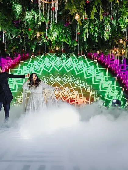 A beautiful shot of a couple's performance with a dry ice effect, making it look like they are dancing on clouds. The LED backdrop adds to the magical, futuristic vibe of the sangeet.