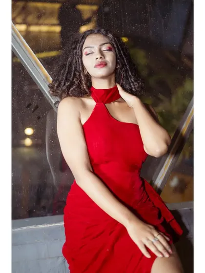 A model wearing the red halter-neck gown for a nighttime shoot. The color looks incredibly vibrant and powerful, perfect for making an entrance.