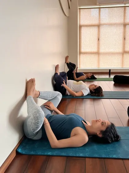 Using the wall to explore a reclined hip-opening pose. The wall provides feedback and support, allowing for a deeper release.