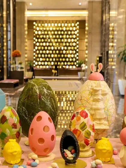 A collection of large, decorative chocolate Easter eggs. These can serve as both a dessert and a stunning centerpiece for your event.