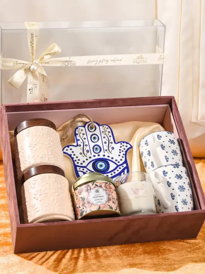 A clear-top view of the Hamsa hand hamper. The transparent lid allows a beautiful preview of the thoughtful gifts inside, including the mugs, jars, and candle.