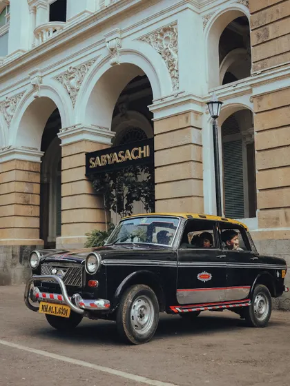 A 'kaali-peeli' taxi waiting outside the Sabyasachi flagship store in Mumbai. This image is a beautiful contrast of everyday transport and high-end luxury fashion.