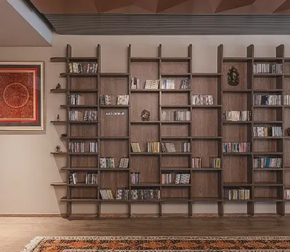 We designed this 'Library of Music' for a client with an extensive collection. The custom-built wooden bookshelf features an irregular, geometric pattern, turning a storage unit into a sculptural art piece that reflects the owner's passion.