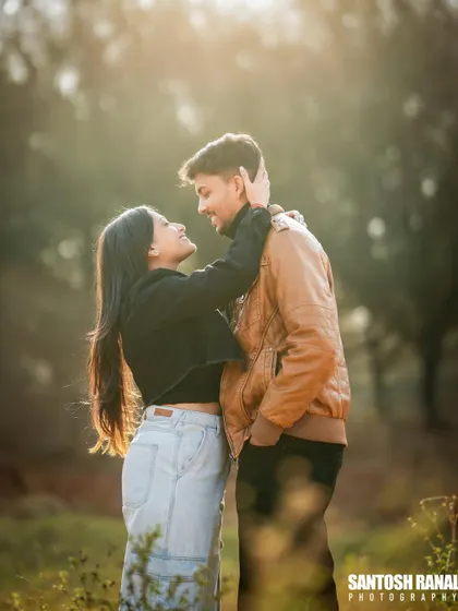 A romantic portrait of a couple in a field, with beautiful backlighting creating a dreamy, hazy effect.