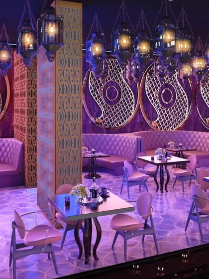 Another perspective of the Arabic-themed lounge, focusing on the plush, tufted seating arrangements in shades of purple and pink. The design uses ornate decorative panels and intricate floor patterns to fully develop the luxurious and exotic theme.