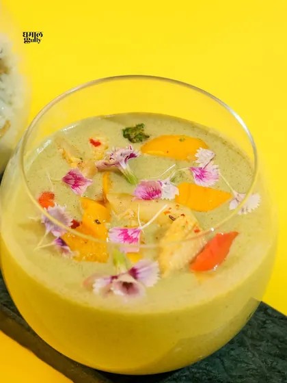 A detailed close-up of my Thai Green Curry. You can see the creamy texture of the coconut broth and the vibrant colors of the vegetables and edible flowers floating on top. It’s a dish designed to be as beautiful as it is delicious.