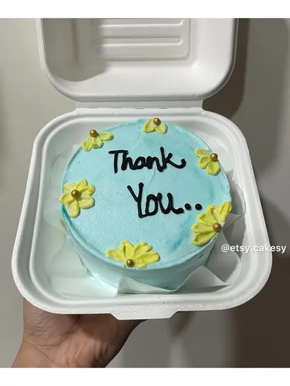 A thoughtful "Thank You" bento cake with small yellow flowers.
