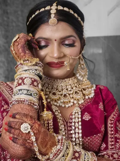 This artistic shot focuses on the bride's stunning jewelry and detailed henna. The makeup was designed to complement these elements, with a focus on shimmering eyeshadow and a flawless complexion.
