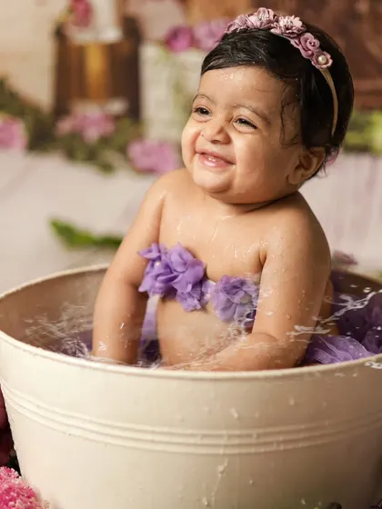 All smiles during her post-cake smash bath! The water splash session is a fun way to get clean and capture even more happy photos.