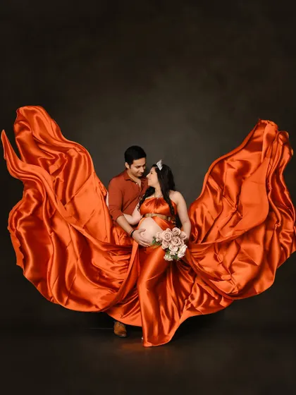 We love creating dynamic shots like this one, where the flowing orange satin gown seems to dance around the couple, capturing a moment of pure connection.