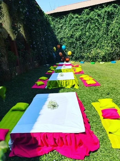 For a relaxed and casual Mehandi, we arranged low seating on the lawn with colorful mattresses and pillows. This setup encourages guests to mingle and enjoy the festivities in comfort.