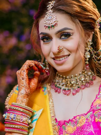 A close-up portrait of the bride from her Mehendi, her smile and colorful jewelry shining brightly.