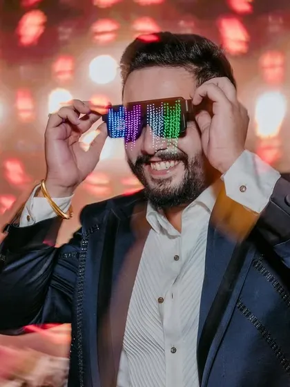 The groom looking cool in futuristic LED glasses on the dance floor. This shot captures the fun and modern vibe of their sangeet party.