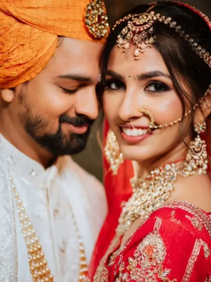 A stunning close-up of a North Indian couple, highlighting the bride's intricate jewelry and radiant smile.