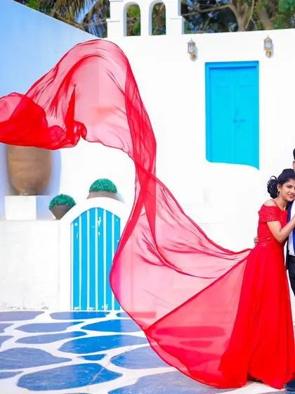 Another beautiful shot with the flowing red gown, creating a sense of drama and romance against the clean white and blue architecture.