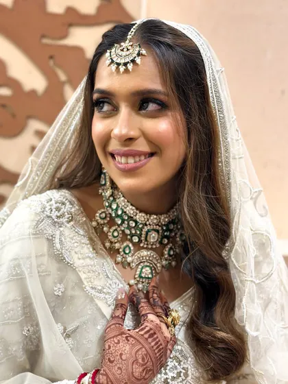 A close-up of the bride's happy expression, showing the flawless application of makeup that enhances her features.