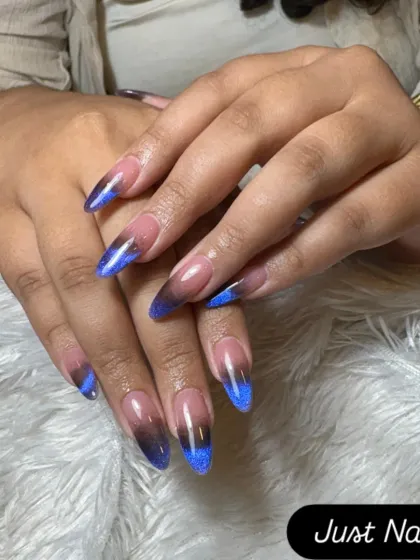A dramatic cat-eye ombre effect. This design transitions from a nude base to a black tip with a vibrant blue magnetic shimmer.