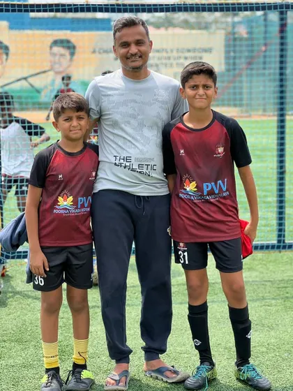 A father with his two sons at our academy. We are proud to be a place where families can share their passion for the beautiful game.