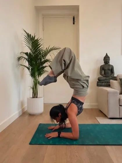 Scorpion style forearm stand on a teal mat, feet dropping towards my head.