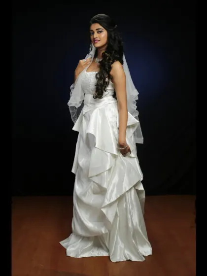 A full length studio portrait of our tiered white wedding gown. This rental is perfect for creating classic and elegant pre-wedding photos.