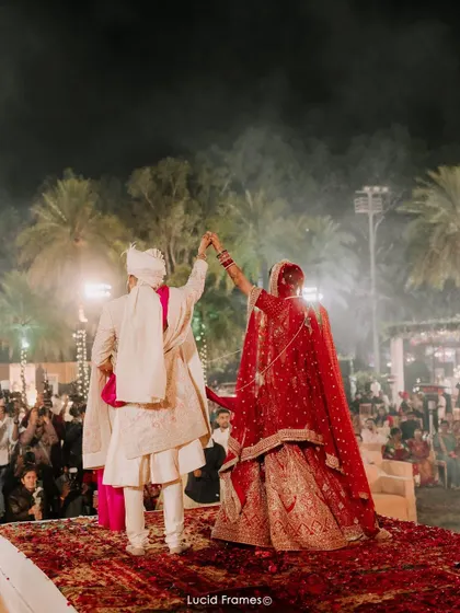 The couple raises their hands in celebration on stage, a perfect end to their wedding ceremony.