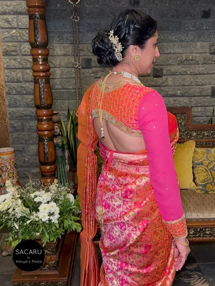 A client turning heads in a backless, full-sleeve blouse with elaborate embroidery, paired with a vibrant patola saree.