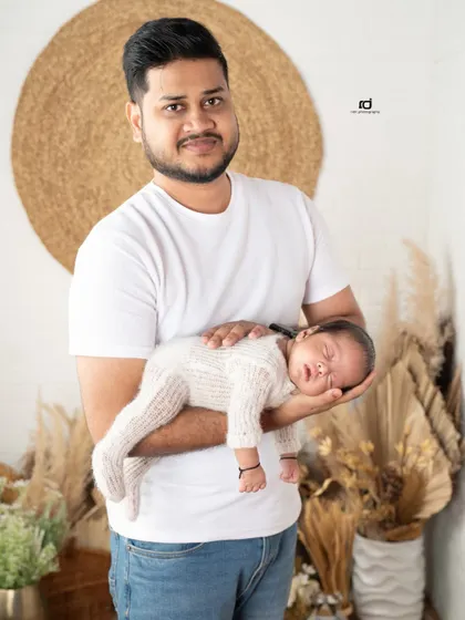 A father's strong and gentle hands holding his tiny baby. This portrait beautifully contrasts the father's strength with the newborn's delicate size.