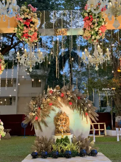 A wider view of the Ganesha setup, framed by hanging chandeliers and floral arrangements, creating a truly divine atmosphere.