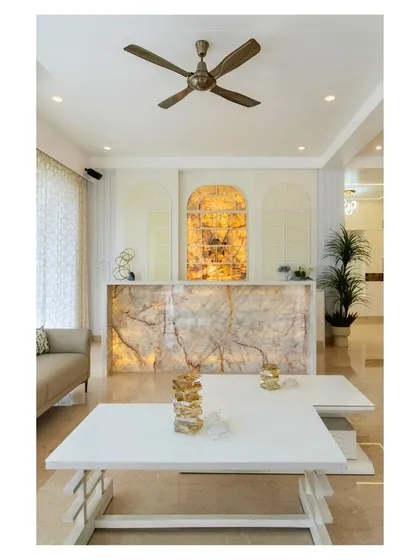 A full view of the living room featuring the backlit onyx bar. The clean lines of the white coffee tables and the neutral sofa allow the glowing onyx to be the undeniable star of the space.