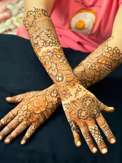 Another view of the personalized floral henna, showcasing the intricate patterns on both hands.