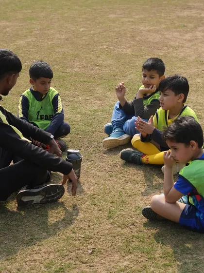 A coach sitting with his players. Success is no accident; it's the result of hard work, perseverance, and a love for what you do.