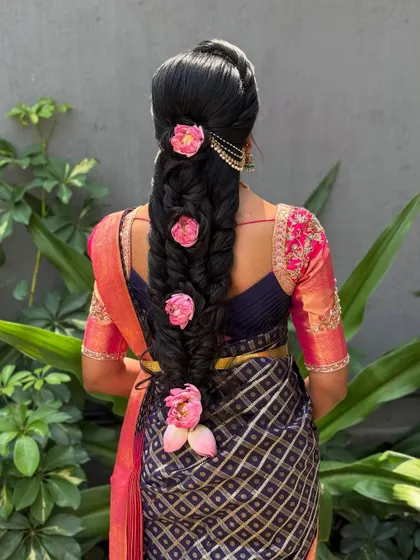 This modern braid is decorated with large, beautiful pink flowers placed along its length. The style is bold and romantic, perfect for making a statement.