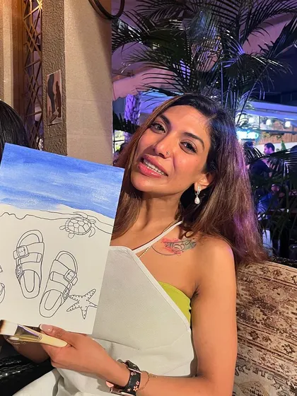A participant proudly shows off her beach-themed Birkenstock painting. The custom designs were a huge hit.