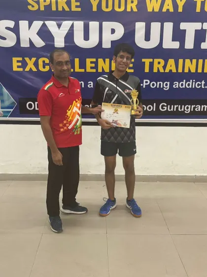 A coach stands proudly with one of our young achievers at the SkyUp Open Table Tennis Tournament. This player won in the Under-15 category and also placed in the Under-13 group.
